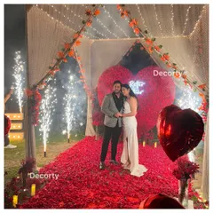 The happy couple celebrating their engagement with cold pyro fireworks, surrounded by a sea of red roses. I can arrange for special effects to add extra sparkle to your big moment.