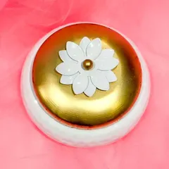 A top-down view of the white and gold metal box, showing the beautiful floral detail on the lid. I can customize the contents to include anything from a kumkum set and bangles to a blouse piece and betel nuts.