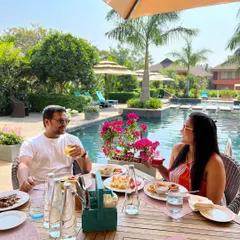 A couple enjoys a leisurely meal by the pool. This image, shared by a guest, perfectly captures the relaxed and luxurious atmosphere of a staycation at our resort.