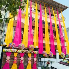 Another angle of the festive home decoration, showing how the colorful drapes and hanging umbrellas transform the entire facade of the building.