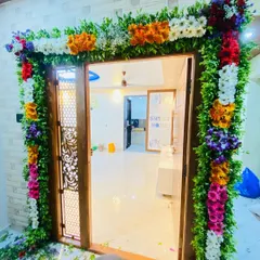 A slightly different angle of the full floral door frame. This shows how the decoration looks from the side, highlighting the thickness and richness of the flower and leaf arrangement.