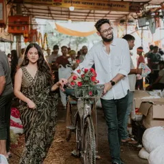 A walking shot through the flower market, with the groom guiding a bicycle filled with roses. This image feels like a scene from a romantic film, set in a real-world location.
