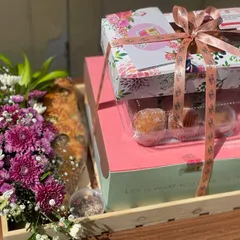 A sweet-focused custom hamper, featuring a box of my Italian stuffed donuts, a savoury pull-apart bread, and a small floral arrangement. It's a perfect gift for someone with a sweet tooth.