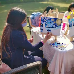 Another artist at work during our sunny, outdoor painting event, adding her personal touch to the iconic swirling sky.