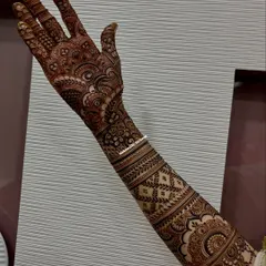 A full-arm bridal mehendi, rich with traditional Indian motifs. The design flows from the palm to the elbow, creating a seamless and elegant look.