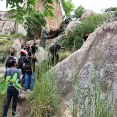 A group of guests navigates a rocky section of our trekking path. Our guided walks cater to various fitness levels and offer a safe way to explore the terrain.