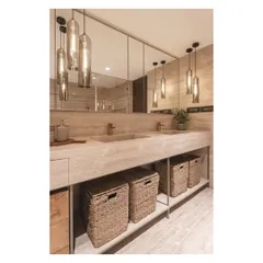 The warm glow from the pendant lights reflects in the large mirror, making the master bath feel spacious and inviting.