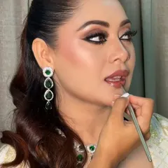 A moment from the process of creating a flawless Nikkah look. Here, I am carefully applying a natural lip shade to complete the bride's elegant makeup.