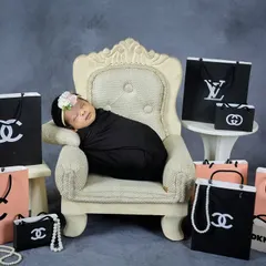 A touch of glamour for this little fashionista. This fun, high-fashion theme uses miniature designer-inspired shopping bags for a playful and stylish newborn portrait.