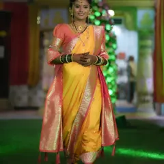 A full-length view of a bride in a stunning yellow and pink Nauvari saree. My draping service ensures the saree is comfortable and perfectly pleated for the entire ceremony.