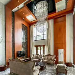 Another perspective of the luxurious living area, emphasizing the verticality of the space. The design combines warm wood paneling with reflective surfaces to enhance the feeling of grandeur and light.