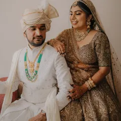A lovely seated portrait of the couple, showcasing their coordinated outfits and the bride's stunning jewelry.