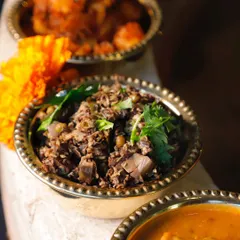A close-up of the Banana Blossom Thoran. You can see the intricate texture of the finely chopped blossom mixed with lentils and spices. It's a special dish, available exclusively on preorder.
