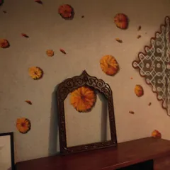An angled shot of the traditional kolam and marigold mural, showing how it wraps around a corner and integrates with the room's furniture. This demonstrates how I design wall art to complement the existing architecture and interior decor of a home.