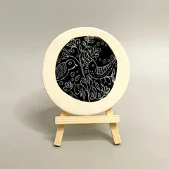 This beautifully hand-painted ceramic tile, featuring a sgraffito bird design, is a stylish and unique way to jazz up your home decor. It's a perfect addition to a bookshelf or side table.