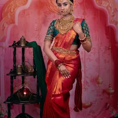 A full-length view of this stunning dusky bride. The red and green Kanjeevaram saree is a classic choice, and the makeup is balanced to complement the rich colors without being overpowering.