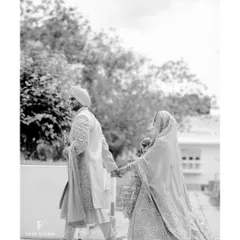 A timeless black and white shot of the couple walking hand-in-hand, the bride's veil trailing behind her, creating a sense of movement and grace.