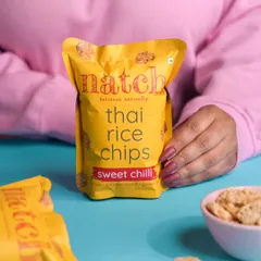A lifestyle shot for Natch's Thai Rice Chips, using color and a human element to create a relatable and vibrant image for social media.