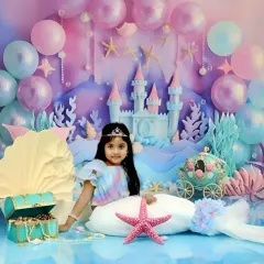 We bring fairy tales to life with our enchanting 'Little Mermaid' setup. This elaborate underwater scene features a castle, pastel balloons, and shimmering seashells, creating a magical world for your child's portrait.