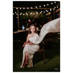 The bride's modern white gown featured a dramatic, flowing one-shoulder drape, creating a memorable silhouette for their intimate dinner party.