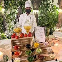 Our live pasta station is always a crowd favorite. Here you can see our chef ready to cook, with a beautiful display of fresh pasta types and a colorful array of toppings like olives, bell peppers, and sun-dried tomatoes for guests to customize their dish.