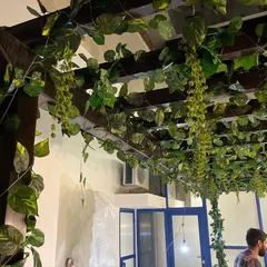 A different angle of the artificial vine ceiling, showing how the foliage wraps around the wooden beams. This is a low-maintenance solution that makes a huge impact, perfect for cafes, restaurants, and event spaces.