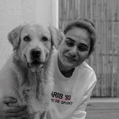 A quiet, loving moment between a woman and her golden retriever. The black and white format enhances the feeling of timeless affection and peaceful connection.