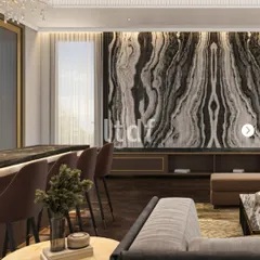 A wider perspective of the living area, showing how the dramatic stone feature wall integrates with the bar and seating. The design maintains a cohesive language of refined materials and natural light, ensuring the space feels unified and thoughtfully composed.