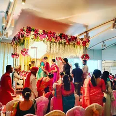 A candid moment from a wedding ceremony, captured under the beautiful floral mandap we designed. It shows how our decor becomes the perfect backdrop for the most important rituals.