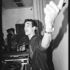 A candid black and white shot capturing a moment of pure joy behind the decks. This is what it looks like when you truly love what you do.