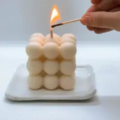 Lighting a classic white bubble candle. You can order these in over 10 different fragrances to fill your home with your favorite scent.