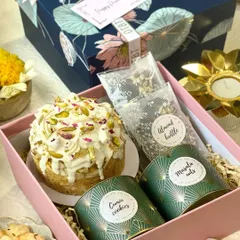 This Diwali hamper combines modern bakes with traditional flavors. It includes a pistachio-crusted tea cake, crunchy almond brittle, savory cumin cookies, and masala nuts, offering a wonderful mix of sweet and savory.