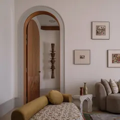This is the parents' suite at our Rehethaan project. The family room is defined by a serene palette of ivories and ochres, with custom-designed sofas and a patterned chaise lounge creating a comfortable and elegant living space.