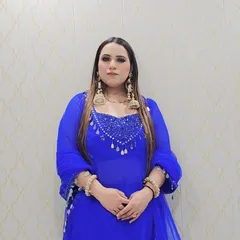 A full-length view of the custom royal blue suit. The Anarkali-style kurta is paired with a matching dupatta adorned with mirror-work tassels, creating a cohesive and striking look.