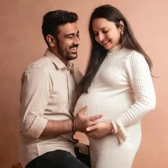 The smiles on their faces say it all. This is a beautiful, candid-style moment from a simple and elegant studio maternity session.