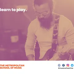 We focus on helping you learn to truly play, not just practice. This image captures an electric guitarist absorbed in their music, reflecting the passion we encourage in all our students.