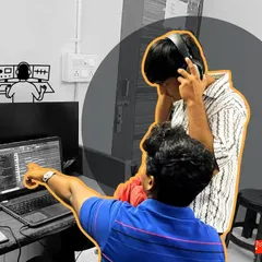 One-on-one guidance is a key part of our teaching philosophy. Here, an instructor points out specific waveforms on the DAW, helping a student understand the nuances of audio editing and mixing.