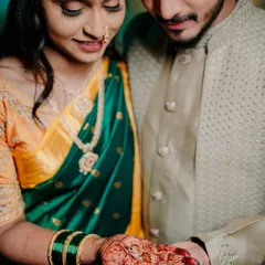 A close-up on the engagement ring, resting in the bride's henna-covered palm as the groom holds her hand. This shot beautifully combines the symbol of their commitment with traditional cultural details.