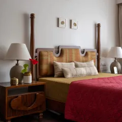 The Thiranottam Bed, designed for the Layam residence, is a direct tribute to the Kathakali art form. The headboard's shape and fabric are inspired by the 'Thiranottam', a moment where the artist peeks over the curtain before a performance, bringing a piece of theatrical heritage into the bedroom.