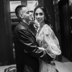 An elegant black and white portrait of a couple sharing a quiet moment. The soft lighting and their gentle embrace create a feeling of romance and intimacy.