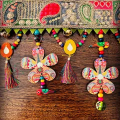 A closer look at the 'Taana Baana' toran. You can see the detailed paisley lace, colorful beads, and the little bird charms that add a touch of whimsy. Every element is made from sustainable, non-plastic materials.