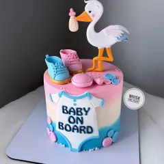 A classic "baby on board" stork delivery cake. This gender-neutral design features pink and blue elements, making it perfect for a baby shower.