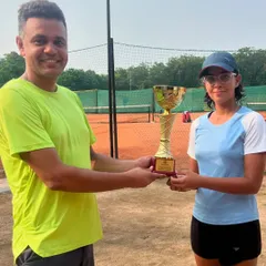 Pakhi Bisht, winner of the U16 girls' title, is presented with her trophy at a UTR tournament. Our players consistently perform at a high level in these competitive events.