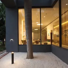 The exterior of the Vis-a-Vis Indian art incubator, where we blurred the lines between inside and out. Floor-to-ceiling glass walls invite the surrounding nature into the experience center, creating a dialogue between art, architecture, and the landscape.