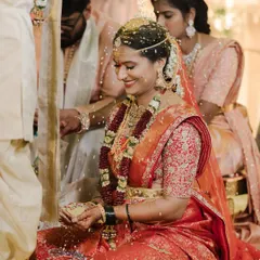 A candid moment of joy during a South Indian wedding ritual, as the bride Sravanthi is showered with sacred rice.