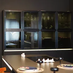 A closer look at the Mibu Residence kitchen, showcasing the elegant smoked glass cabinetry. This feature provides a sophisticated display for glassware while maintaining the kitchen's clean, modern aesthetic.