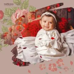 A sweet and gentle portrait from a newborn session. Swaddled comfortably in a basket, this baby's calm smile is the centerpiece of this artistic shot, enhanced with a floral and petal overlay.