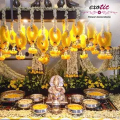 A traditional and ornate Ganpati setup. We used hanging garlands of yellow flowers and a base of fresh florals to create a golden, divine space for this silver Ganpati idol.