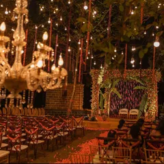A magical evening ceremony under the stars. We created this enchanting atmosphere with hundreds of hanging bulbs and crystal chandeliers, illuminating a traditional marigold mandap. The aisle was a carpet of fresh petals.
