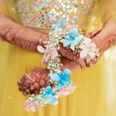 A close-up of one of our pastel floral jewellery sets. I love playing with soft colours like pink and blue, using delicate orchids and baby's breath to create a modern and dreamy look for Haldi or Mehendi.